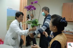 今年三月完成腎臟移植的受贈者許國城（右二）送蘭花祝福李明哲主任及器官移植團隊。（游繡華攝）